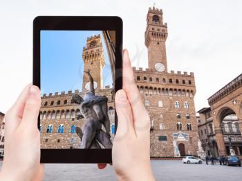 travel concept - tourist photographs sculpture near palazzo vecchio in Florence city on tablet in Italy