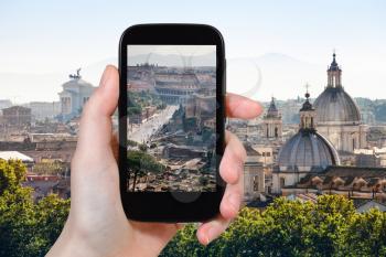travel concept - tourist photographs roman forums in Rome city on smartphone in Italy