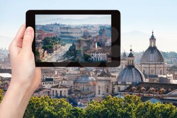 travel concept - tourist photographs coliseum and roman forums in Rome city on tablet in Italy