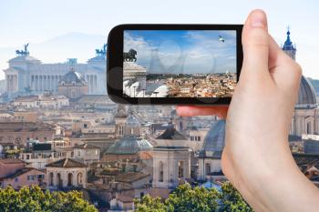 travel concept - tourist photographs Rome skyline on smartphone in Italy