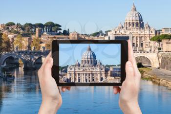 travel concept - tourist photographs St Peter Basilica from Rome city on tablet in Italy