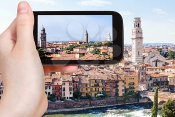 travel concept - tourist photographs Verona city skyline on smartphone in Italy