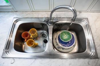 washing of dirty dishes in kitchen sink at home