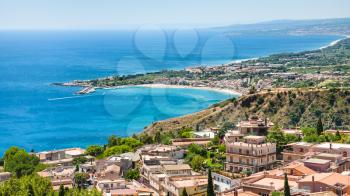 travel to Italy - panorama with Taormina city and giardini naxos town on the coast of Ionian sea from Castelmola village in Sicily in summer day