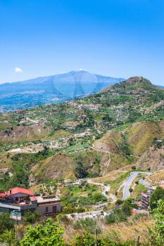travel to Italy - green hills with villages and Etna volcano in Sicily