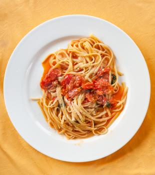 travel to Italy, italian cuisine - above view spaghetti with spicy tomato sauce on white plate in Sicily