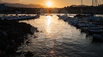 GIARDINI NAXOS, ITALY - JULY 6, 2011: yacht mooring in Giardini Naxos town on sunset. Naxos was founded by Thucles the Chalcidian in 734 BC, and since 1970s it has become a seaside-resort