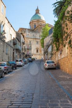 PIAZZA ARMERINA, ITALY - JUNE 29, 2011: street to Duomo Cathedral in Piazza Armerina town in Sicily. Baroque cathedral was built in 17th and 18th cent, on the 15th-cent foundations of former church