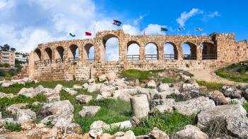 Travel to Middle East country Kingdom of Jordan - wall with flags in Jerash (ancient Gerasa) town