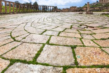 Travel to Middle East country Kingdom of Jordan - wet pavement of Oval Forum in Jerash (ancient Gerasa) town in winter