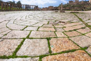 Travel to Middle East country Kingdom of Jordan - wet floor stones of Oval Forum in Jerash (ancient Gerasa) town in winter