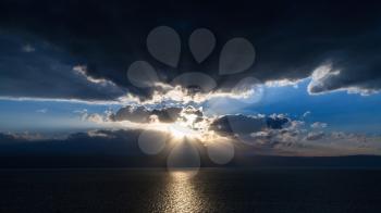 Travel to Middle East country Kingdom of Jordan - sunset in dark blue clouds over Dead Sea in winter evening
