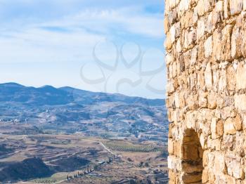 Travel to Middle East country Kingdom of Jordan - outer wall of medieval Kerak castle and rural landscape in winter