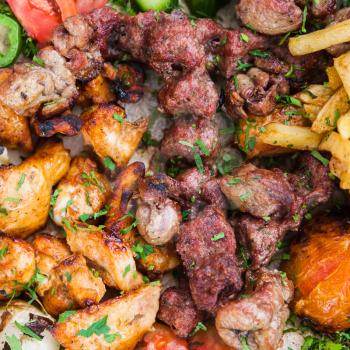 Travel to Middle East country Kingdom of Jordan - top view of many pieces of arabian kebab from veal, lamb and chicken on plate in street cafe in Aqaba city