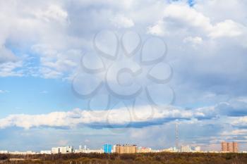 blue sky with white clouds over view of urban park and Moscow city in early spring