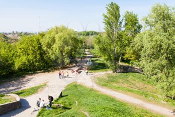KIEV, UKRAINE - MAY 5, 2017: tourists in urban park on Gonchary-Kozhemyaki tract in Kiev city near Landscape alley in spring. The alley passes through the defensive shaft of Kiev of the 10th cent