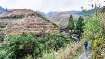 travel to China - bridge over water stream between terraced hills near Dazhai village in area of Longsheng Rice Terraces (Dragon's Backbone terrace, Longji Rice Terraces) in spring season