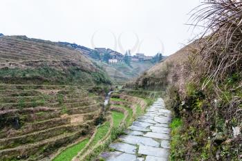 travel to China - pathway between terraced hills near Tiantouzhai village in area of Dazhai Longsheng Rice Terraces (Dragon's Backbone terrace, Longji Rice Terraces) in spring season
