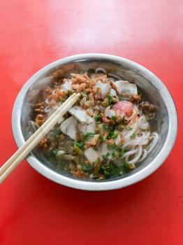 travel to China - dish with udon soup with guilin rice noodles on red table in urban eatery in Longsheng city