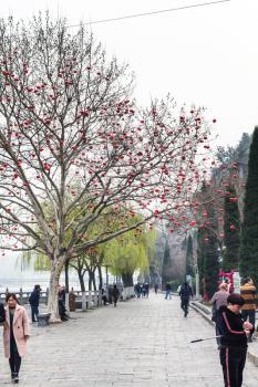 LUOYANG, CHINA - MARCH 20, 2017: tourists on waterfront Yi river on West Hill of Buddhist monument Longmen Grottoes (Longmen Shiku, Dragon's Gate Grottoes, Longmen Caves) in spring season