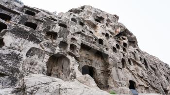 LUOYANG, CHINA - MARCH 20, 2017: carved rocks of West Hill of Chinese Buddhist monument Longmen Grottoes. The complex was inscribed upon the UNESCO World Heritage List in 2000
