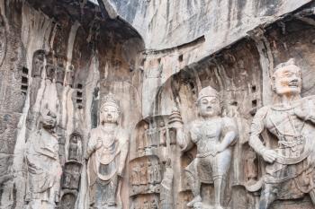 LUOYANG, CHINA - MARCH 20, 2017: carved Buddhist statues in the main Longmen Grotto (Longmen Caves). The complex was inscribed upon the UNESCO World Heritage List in 2000