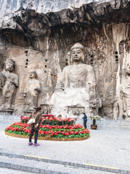 LUOYANG, CHINA - MARCH 20, 2017: people near carved The Big Vairocana statue in main Longmen Grotto (Longmen Caves). The complex was inscribed upon the UNESCO World Heritage List in 2000