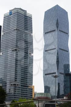 GUANGZHOU, CHINA - MARCH 31, 2017: two glass skyscrapers in Zhujiang New Town of Guangzhou city in spring rainy day. Guangzhou is the third most-populous city in China with population about 13,5 mln
