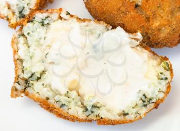 traditional sicilian street food - open spinach stuffed rice balls arancini on plate