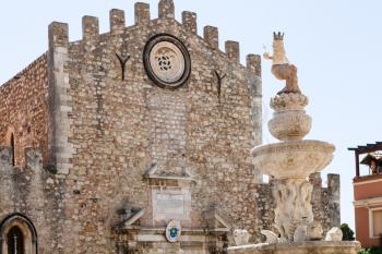 travel to Sicily, Italy - baroque style fountain on Piazza Del Duomo and facade of Duomo di Taormina (Cathedral San Nicolo di Bari) on background in Taormina city in summer day