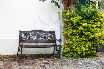 Travel to Germany - wet old bench in residential quarter on Kirchgasse street in Augsburg city in rainy spring day