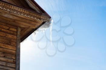 icicle on roof of old wooden house in Suzdal town in spring in Vladimir oblast of Russia