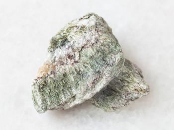 macro shooting of natural mineral rock specimen - raw richterite stone on white marble background from Kovdor region, Kola Peninsula, Russia
