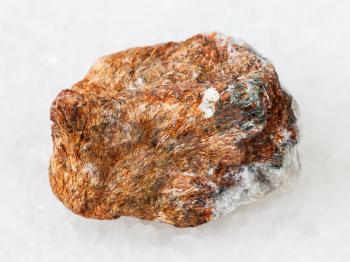 macro shooting of natural mineral rock specimen - piece of normandite stone on white marble background from Khibiny Mountains, Kola Peninsula, Russia