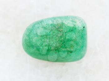 macro shooting of natural mineral rock specimen - polished green Aventurine gem stone on white marble background