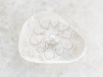 macro shooting of natural mineral rock specimen - polished Rock-crystal gem stone on white marble background