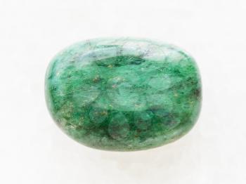 macro shooting of natural mineral rock specimen - polished green beryl gemstone on white marble background