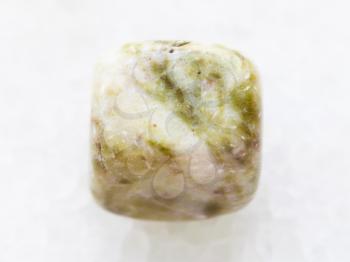 macro shooting of natural mineral rock specimen - tumbled agate gem stone on white marble background