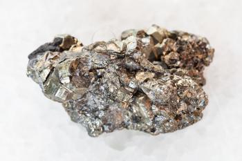 macro shooting of natural mineral rock specimen - raw pyrite stone on white marble background from Mexico
