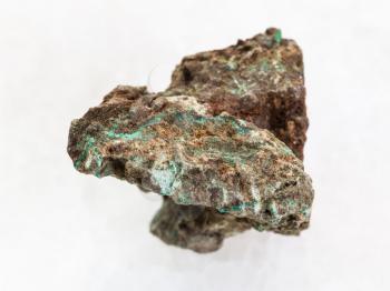macro shooting of natural mineral rock specimen - rough Malachite (copper ore) stone on white marble background
