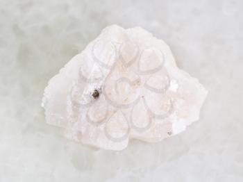macro shooting of natural mineral rock specimen - raw Barite stone on white marble background