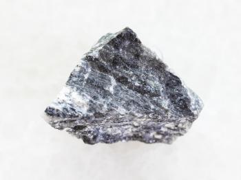 macro shooting of natural mineral rock specimen - rough stibnite (antimonite) ore on white marble background