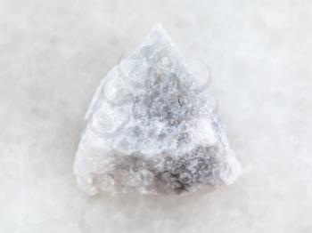 macro shooting of natural mineral rock specimen - raw gray Marble stone on white marble background