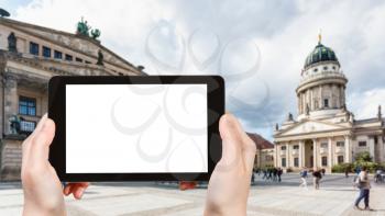 travel concept - tourist photographs Gendarmenmarkt square in Berlin city in Germany in september on tablet with cut out screen for advertising logo