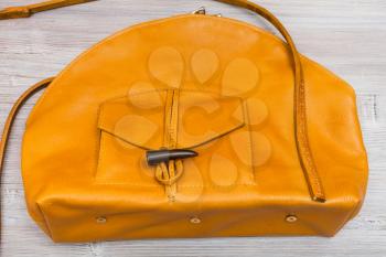 handmade yellow leather bag with pocket on wooden table