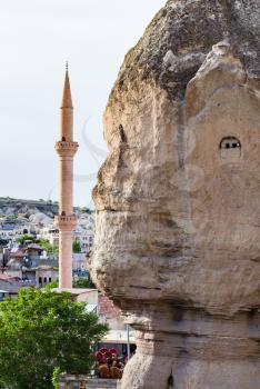 Travel to Turkey - wall of ancient rock-cut house and mosque in Goreme town in Cappadocia in spring