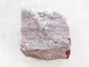 macro shooting of natural mineral rock specimen - rough Rhyolite stone on white marble background
