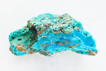 macro shooting of natural mineral rock specimen - piece of Chrysocolla stone in copper sandstone on white marble background from Zabaykalsky Krai of Russia