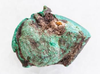 macro shooting of natural mineral rock specimen - rough malachite stone on white marble background