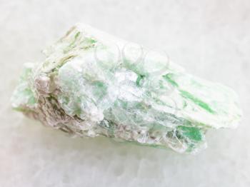 macro shooting of natural mineral rock specimen - raw green talc stone on white marble background from Shabrovsky (Shabry) district of Sverdlovk region, Ural Mountains, Russia